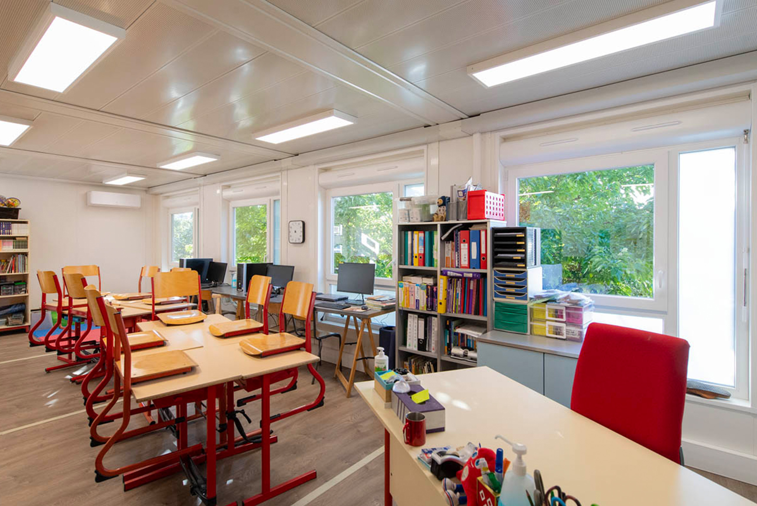 Salle de classe modulaire ALGECO® avec vue sur bureau du professeur et ordinateurs