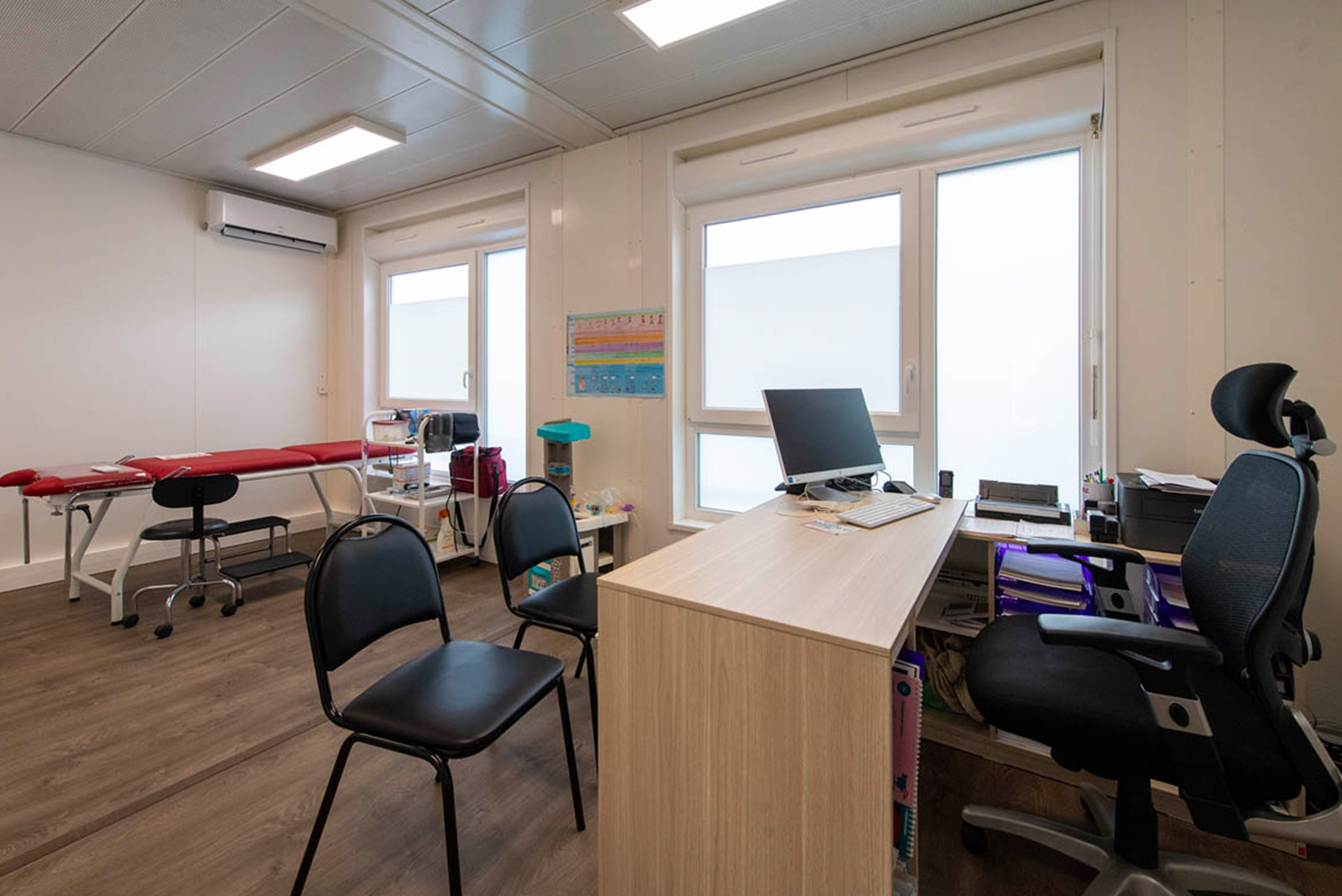 Cabinet médical modulaire ALGECO® avec banc, bureaux, ordinateur, climatisation et fenêtre entrée sur la gauche