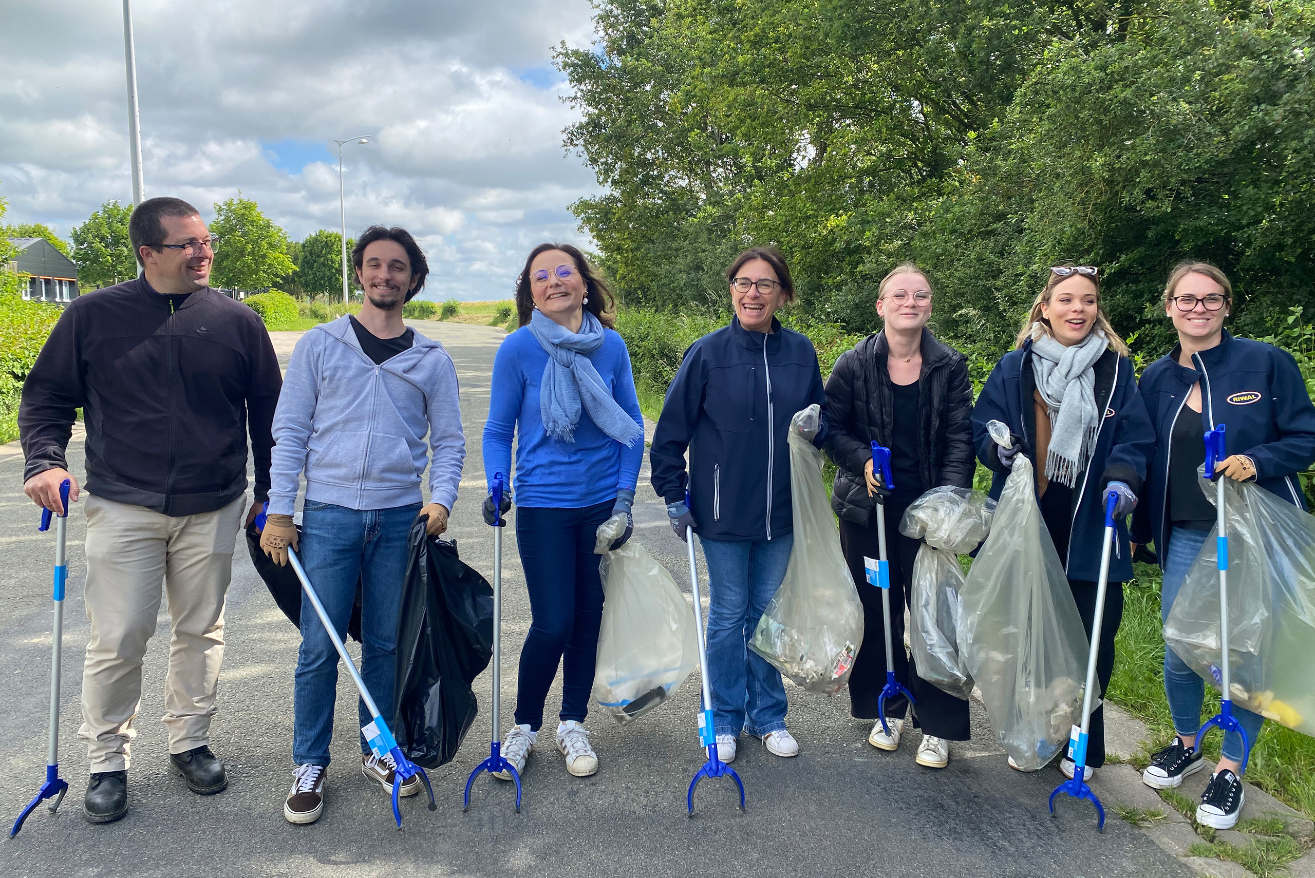 groupe de personnes sur une route participant à une activité de nettoyage en plein air