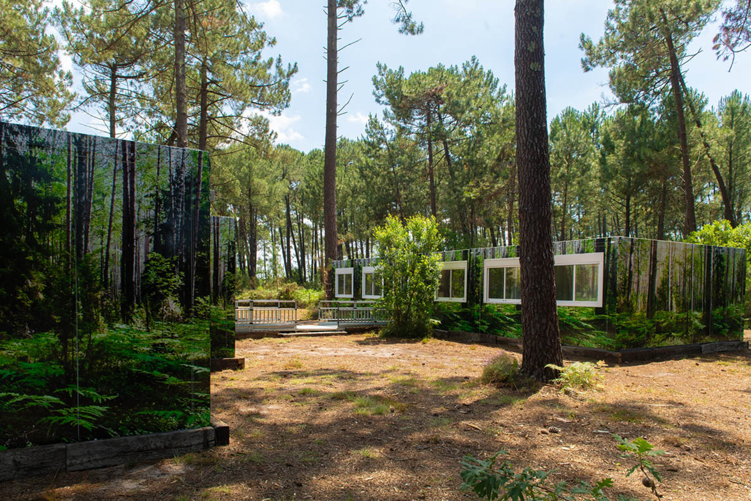 vue sur la droite sur la gauche du complexe de logements modulaires ALGECO® temporaire avec façade en trompe l’œil dans une forêt d’Arès (Bassin d’Arcachon)