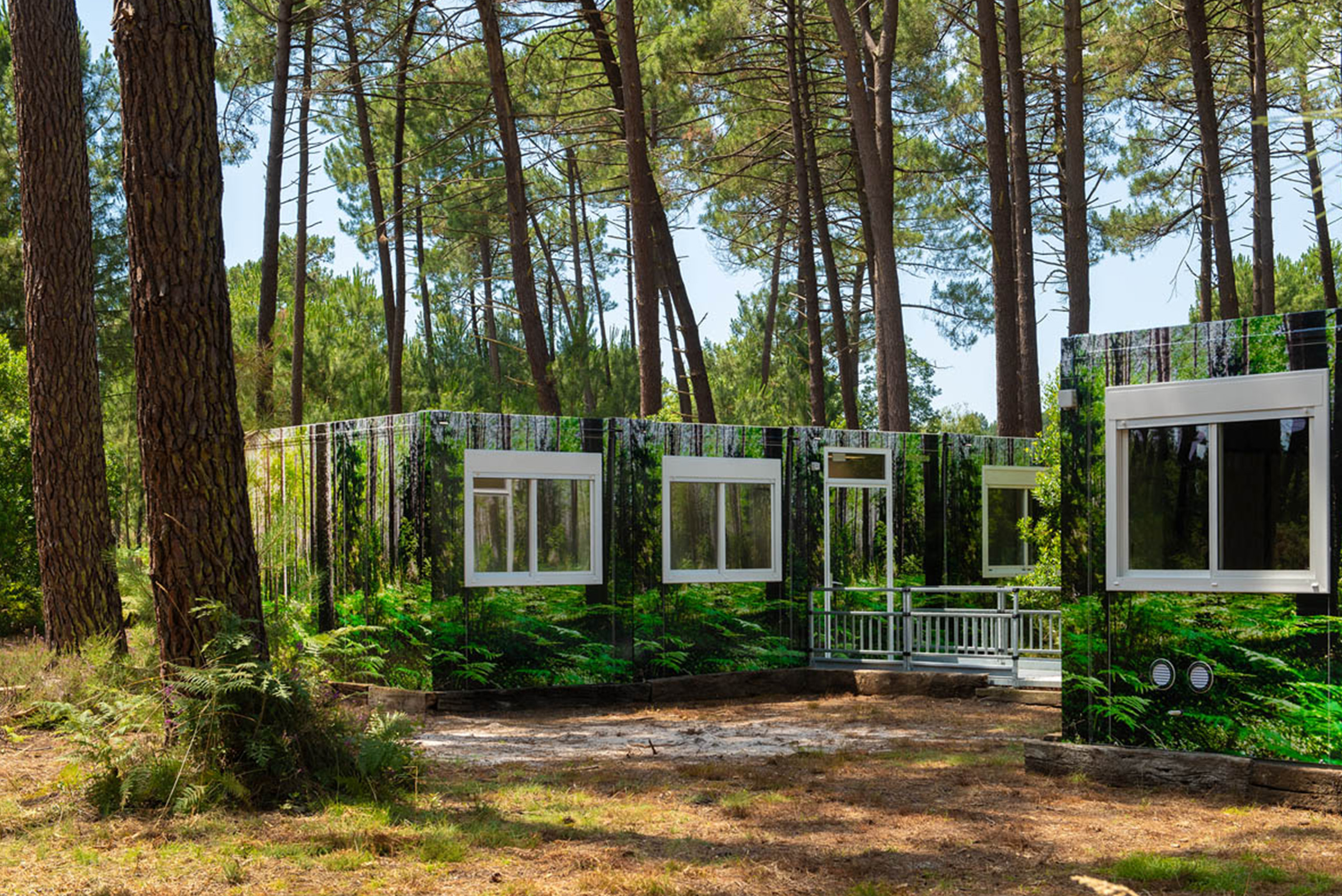 vue sur la gauche du complexe de logements modulaires ALGECO® temporaire avec façade en trompe l’œil dans une forêt d’Arès (Bassin d’Arcachon)