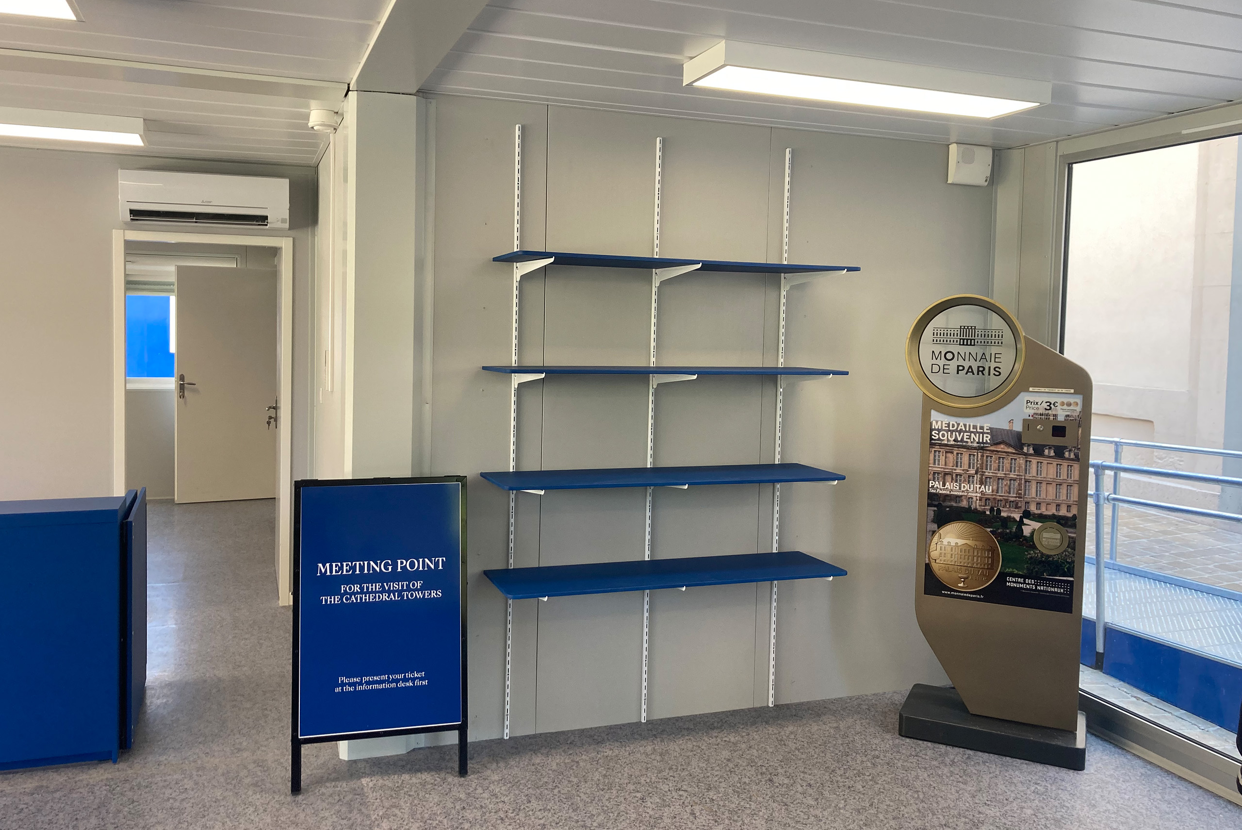 Intérieur de la boutique modulaire ALGECO® avec étagères et signalétique pour le Palais du Tau de Reims