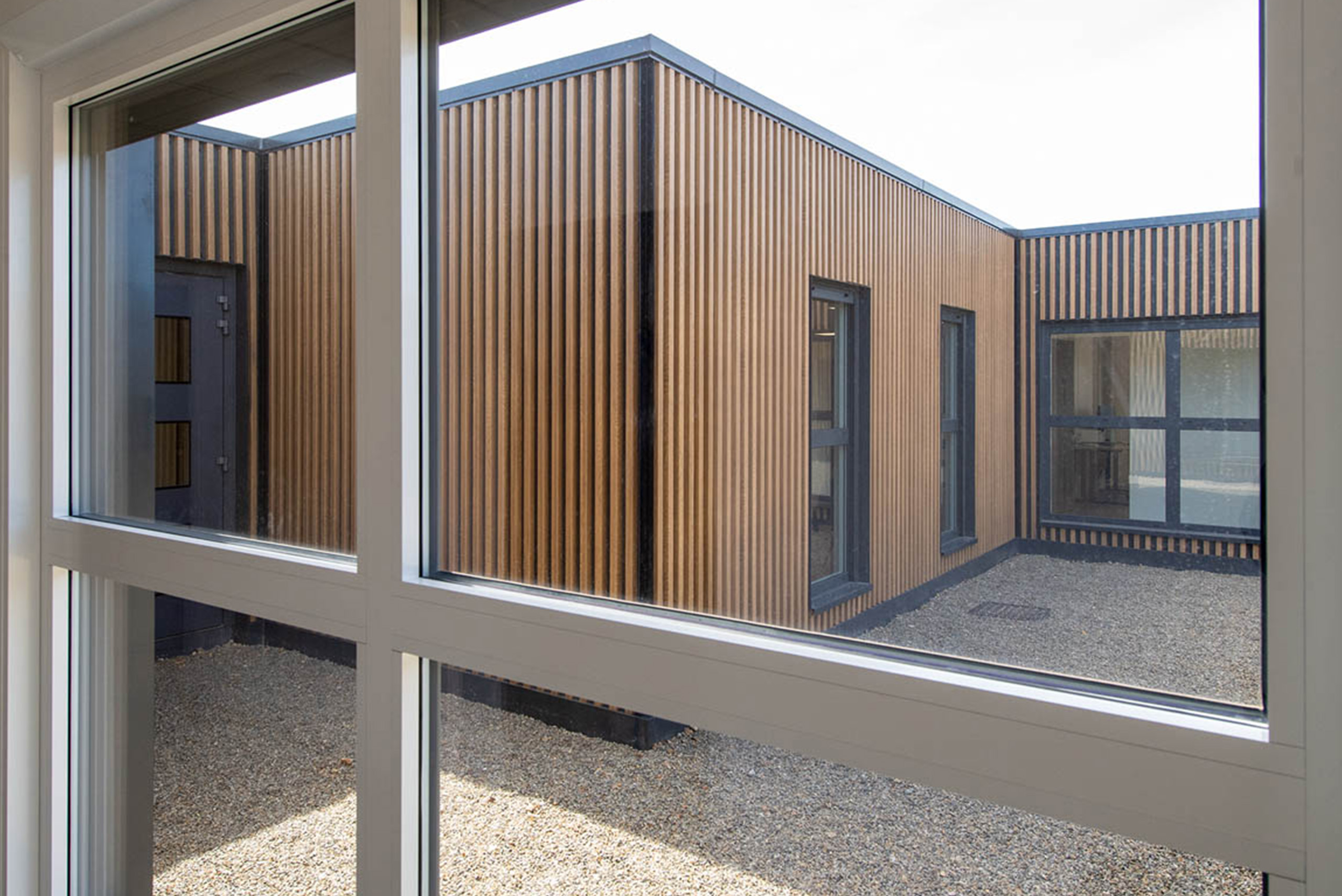 vue vers l’extérieur de bâtiments modulaires avec bardage bois et métal