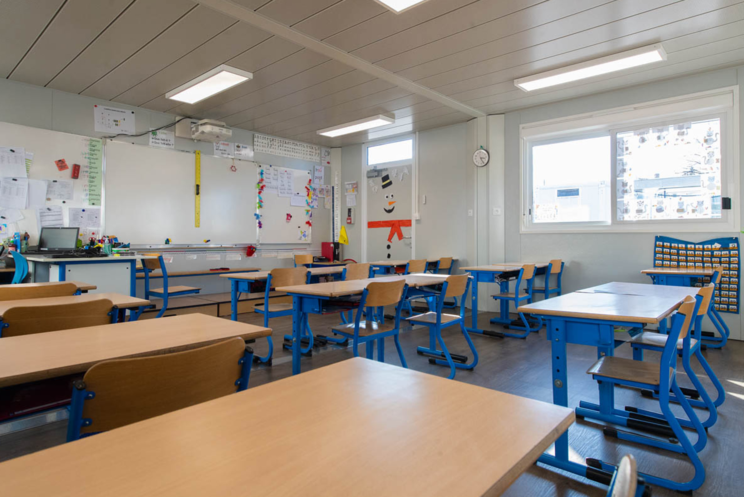 Salle de classe élémentaire modulaire ALGECO® avec bureaux deux places et tableau blanc interactif
