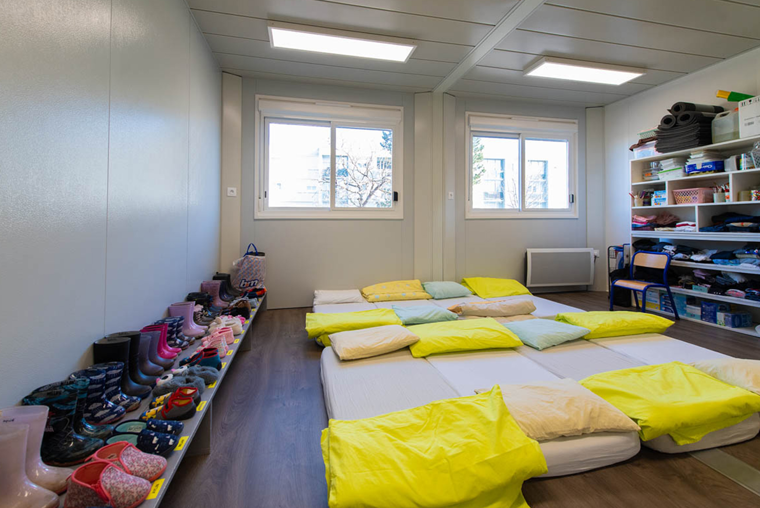 Salle de sieste modulaire ALGECO® pour enfants avec matelas au sol et chaussures rangées