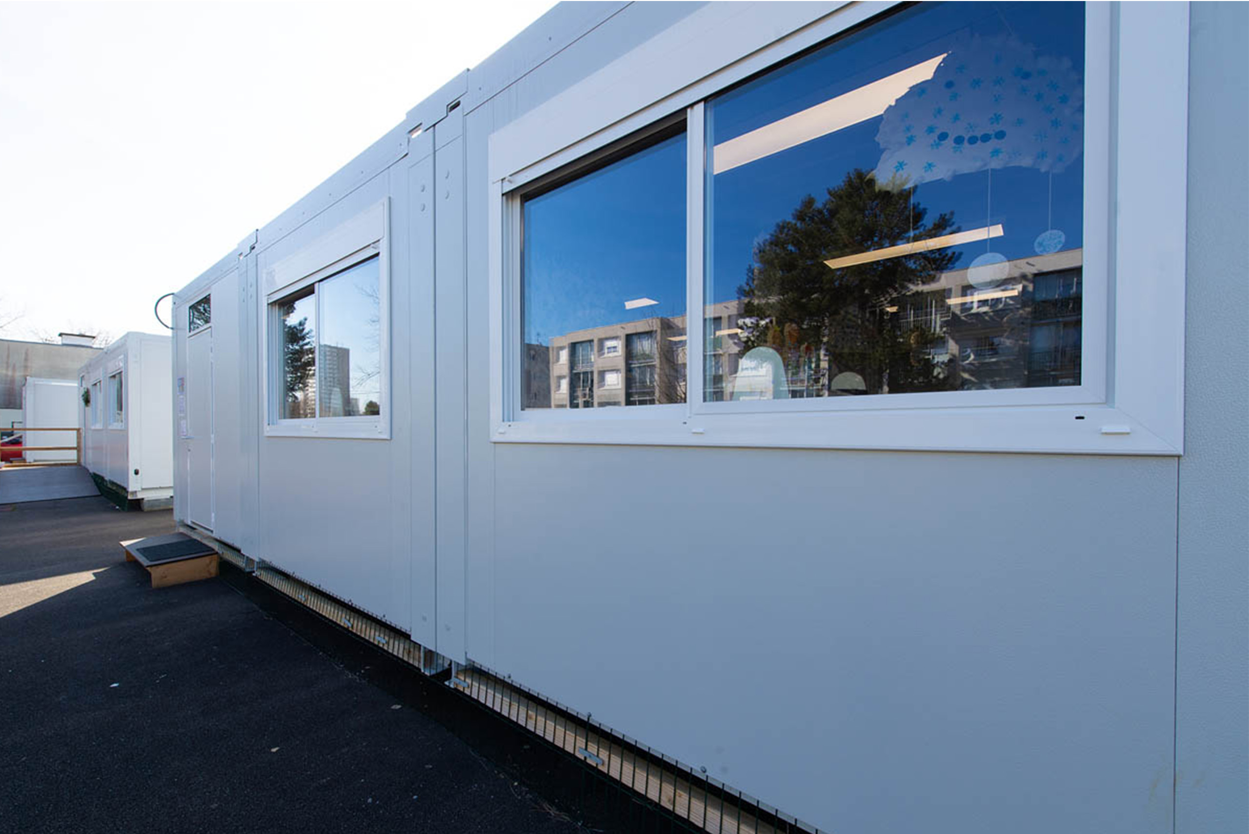 Vue extérieure de bâtiments scolaires modulaire ALGECO® gris avec fenêtres