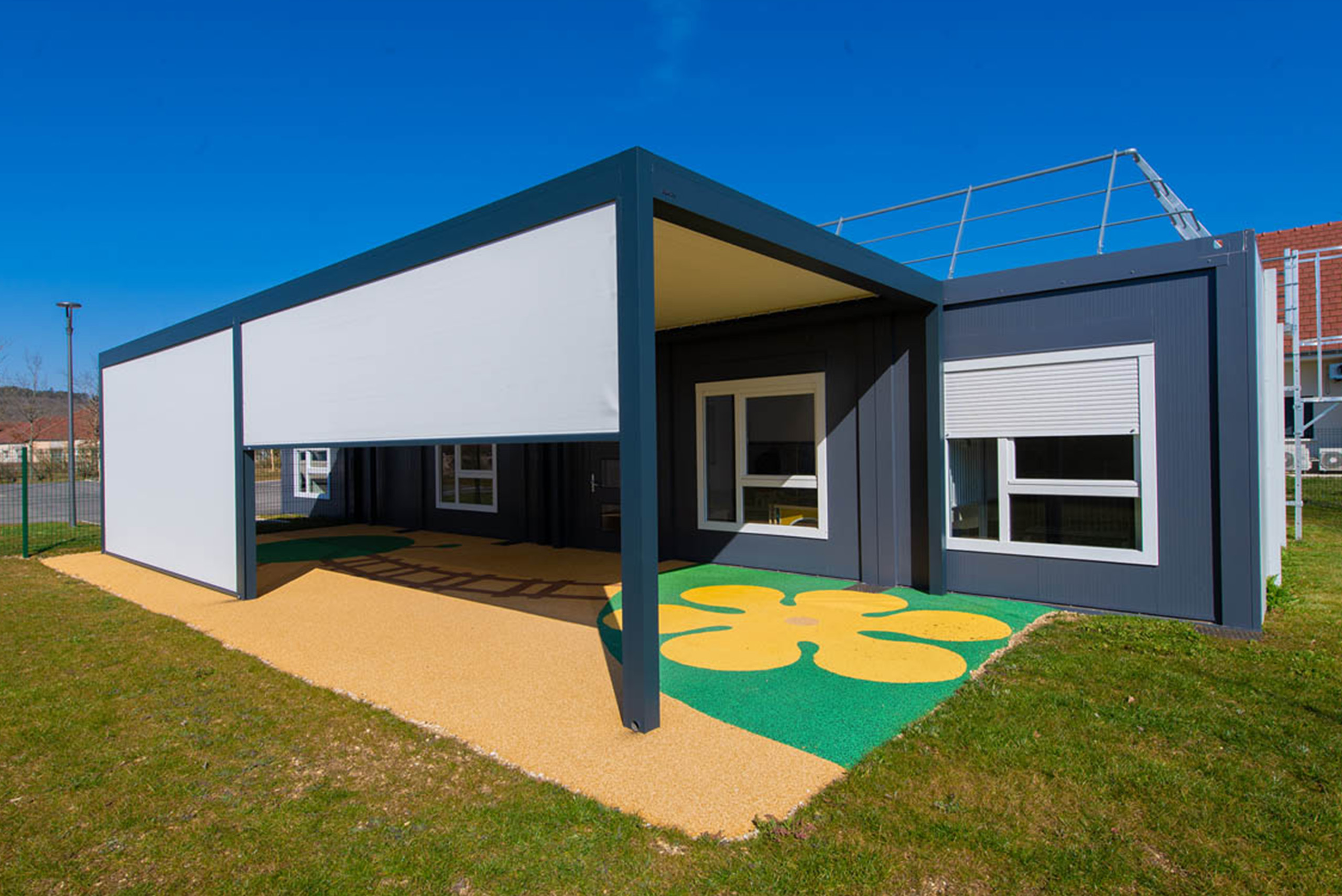 Façade extérieure de la crèche modulaire ALGECO® « Les libellules du Suzon » à Messigny-et-Vantoux avec pergola et sol coloré