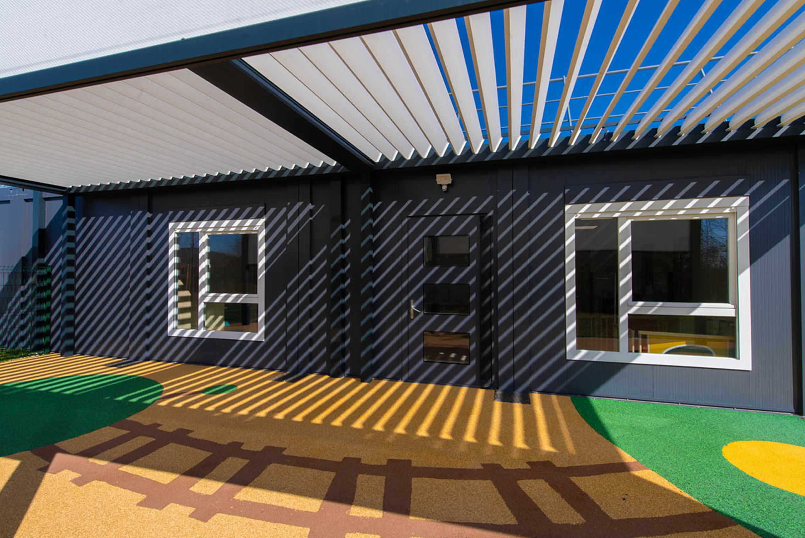 Pergola bioclimatique de la crèche modulaire ALGECO® à Messigny-et-Vantoux avec ombres au sol