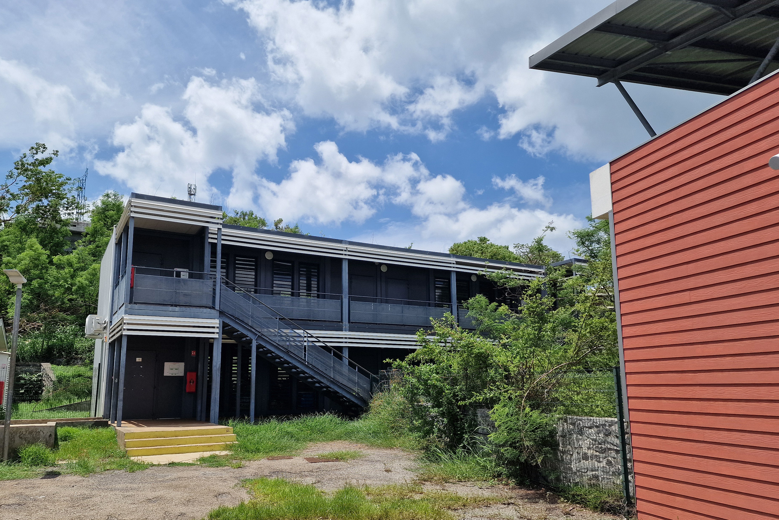 École modulaire ALGECO® à deux niveaux avec escalier extérieur à Mayotte dans un environnement tropical
