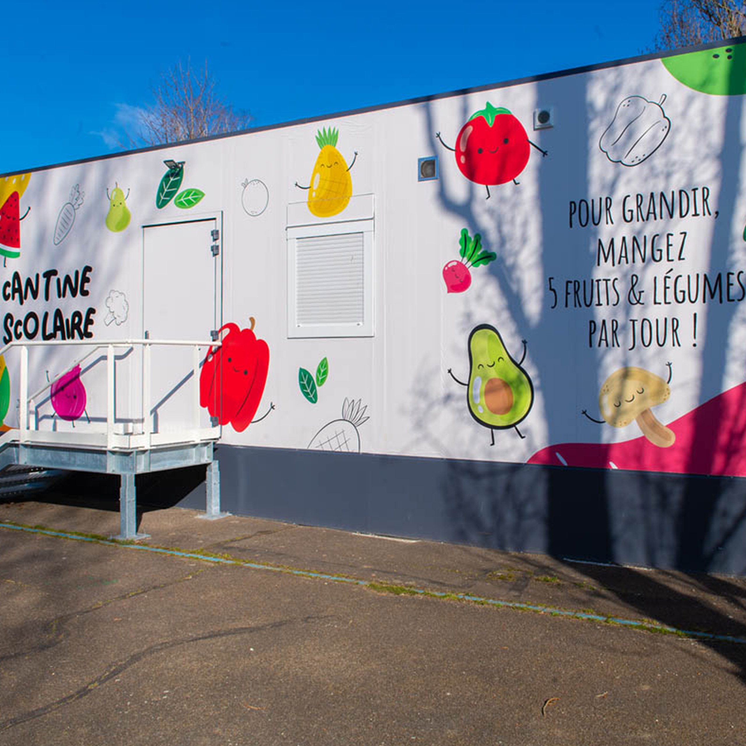 Façade colorée d’une cantine scolaire modulaire ALGECO® décorée de fruits à Chalon-sur-Saône