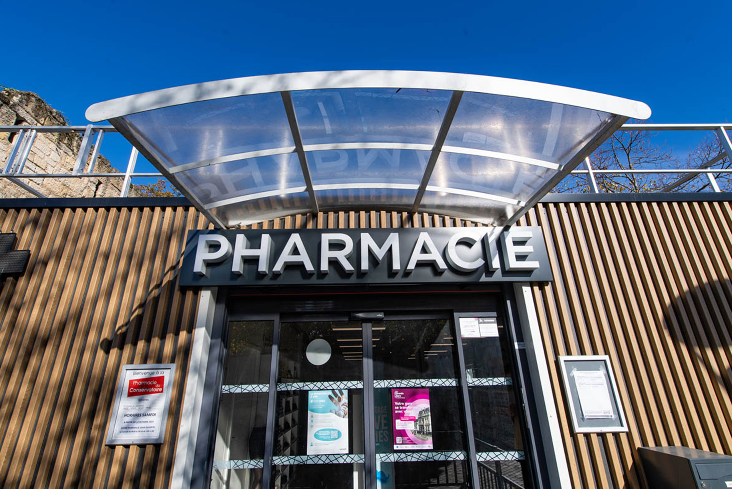 Entrée de la pharmacie modulaire ALGECO® temporaire dans le quartier Canopia à Bordeaux avec auvent transparent