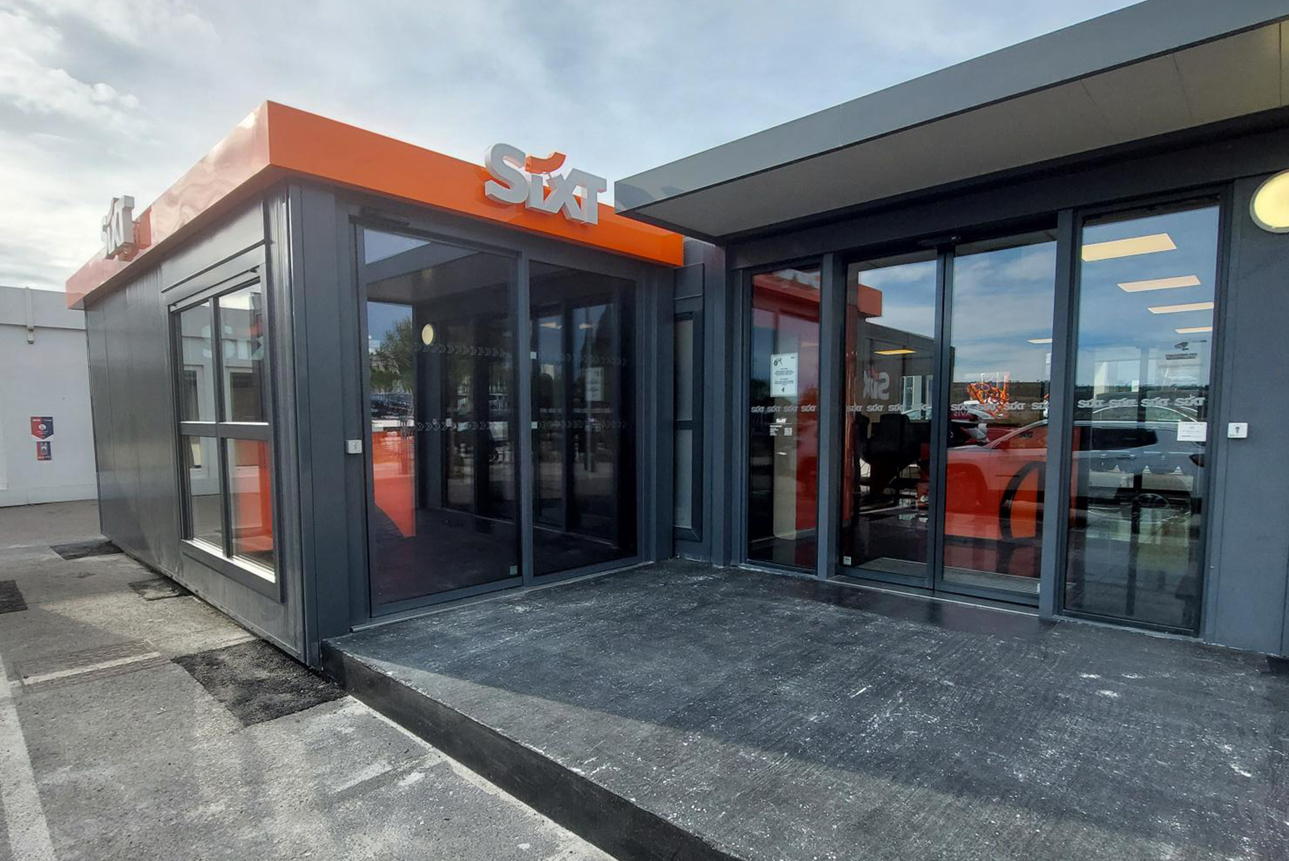 Bâtiment modulaire ALGECO® utilisé comme agence de location de voitures Sixt avec façade vitrée
