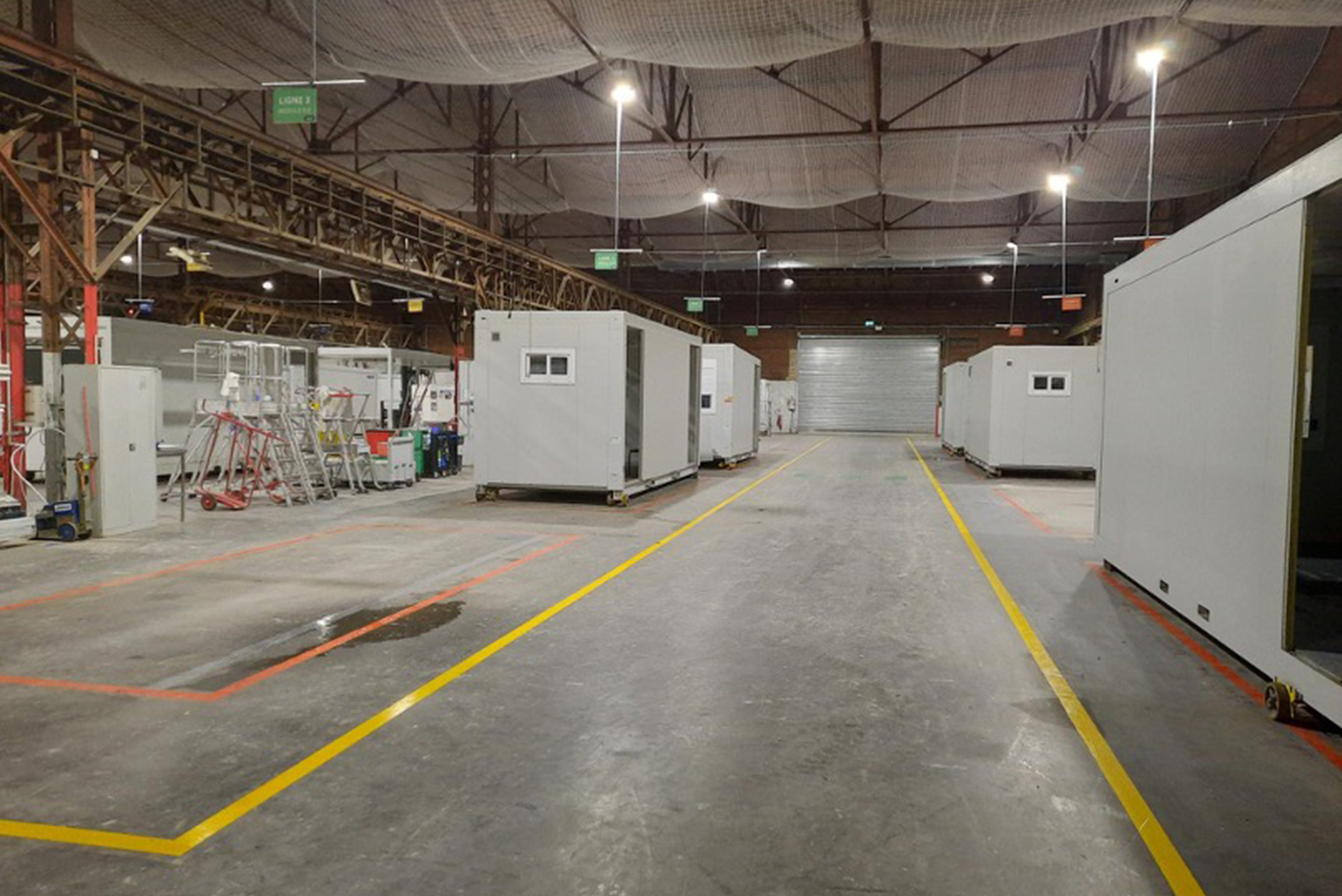 Ligne de production de bâtiments modulaires ALGECO® alignés dans un atelier industriel