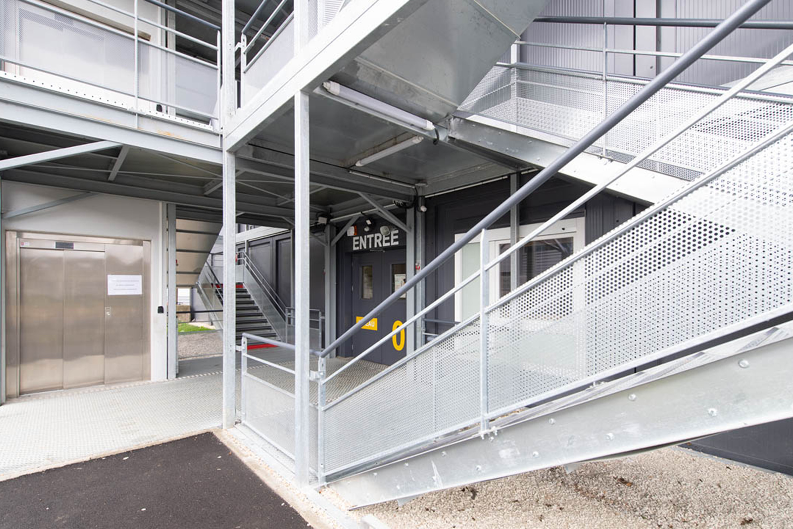 Ascenseur PMR et escalier extérieur du lycée modulaire ALGECO® Pierre de Coubertin à Meaux