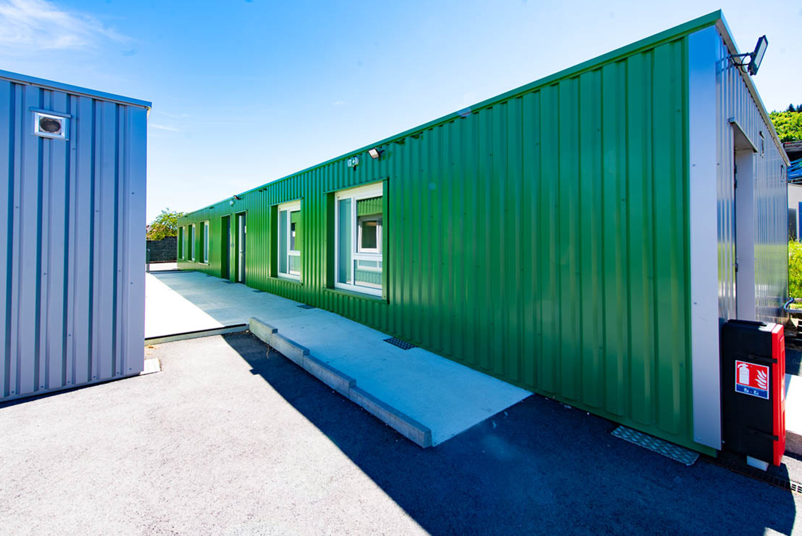 Façade latérale verte des salles de classe modulaires ALGECO® ENILEA à Mamirolle