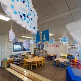 Salle de classe maternelle modulaire ALGECO® décorée avec des créations hivernales suspendues