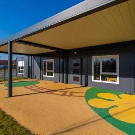 Façade de la crèche modulaire Algeco à Messigny-et-Vantoux avec pergola bioclimatique et sol ludique