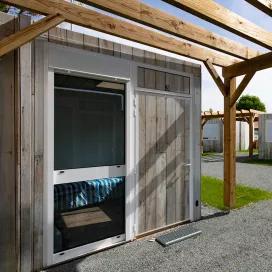 Entrée d’un studio modulaire ALGECO® avec bardage bois et pergola dans le village d’hébergement pour demandeurs d’asile à Villenave-d’Ornon