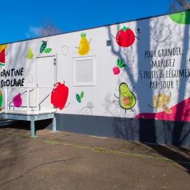 Façade colorée d’une cantine scolaire modulaire ALGECO® décorée de fruits à Chalon-sur-Saône