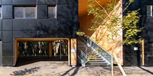 Bâtiment modulaire ALGECO® moderne en façade noire avec escalier extérieur et espaces verts