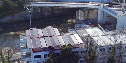Vue aérienne d’un toit modulaire équipé du système SOLAR 4.0 d’Altempo avec panneaux photovoltaïques près d’une voie ferrée