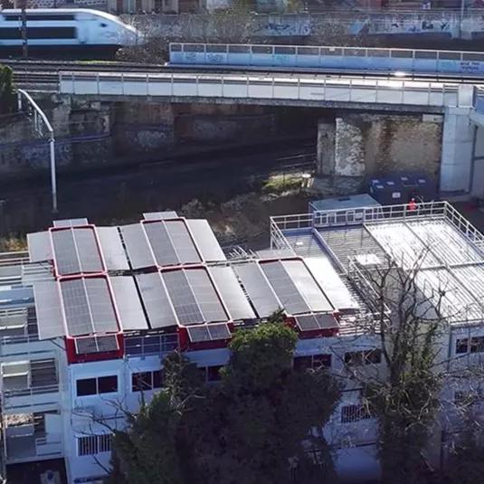 Vue aérienne d’un toit modulaire équipé du système SOLAR 4.0 d’Altempo avec panneaux photovoltaïques près d’une voie ferrée