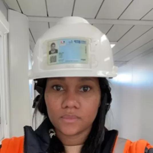 Marie Colozzi conductrice de travaux ALGECO avec casque de chantier et gilet de sécurité dans un bâtiment modulaire