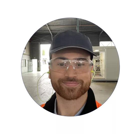  Thomas Despagnot équipé de lunettes de protection et gilet haute visibilité dans un atelier industriel