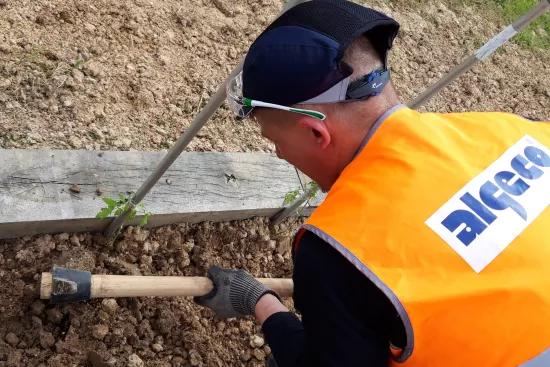 expert Algeco creusant la terre avec une pioche