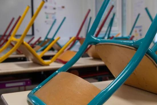 Salle de classe modulaire ALGECO® avec chaises retournées sur les bureaux