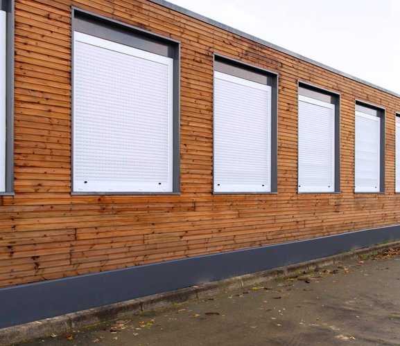 Salle de classe modulaire avec bardage en bois Algeco, volets fermés