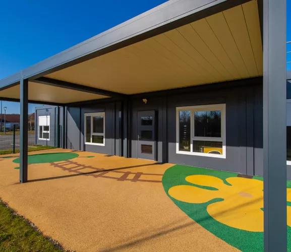 Façade de la crèche modulaire Algeco à Messigny-et-Vantoux avec pergola bioclimatique et sol ludique