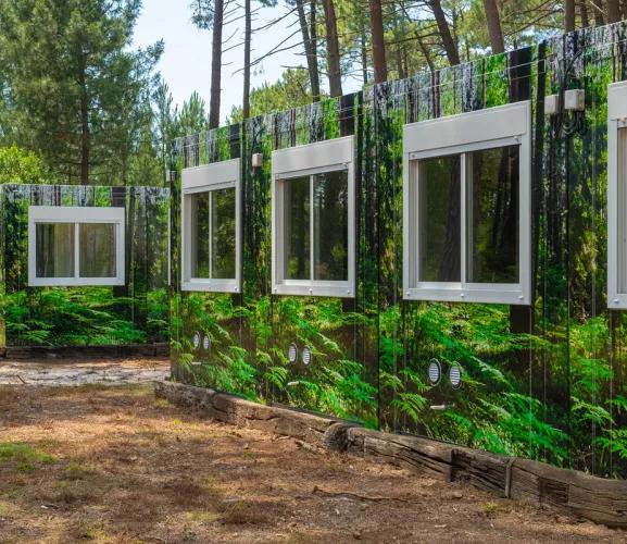 Vue rapprochée d’une des façades du complexe de logements modulaires ALGECO® temporaire avec façade en trompe l’œil dans une forêt d’Arès (Bassin d’Arcachon)