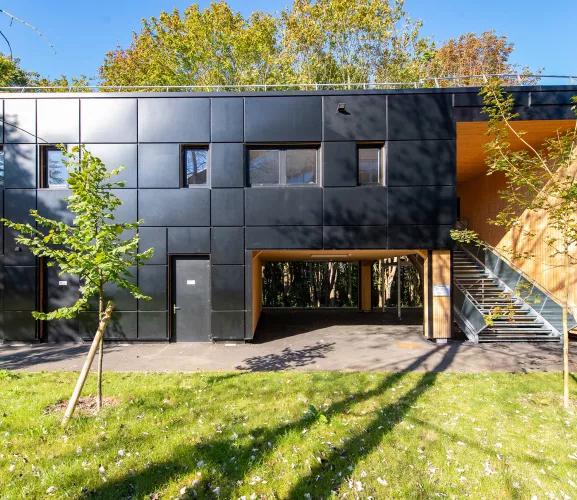 Bâtiment modulaire ALGECO® moderne en façade noire avec escalier extérieur et espaces verts