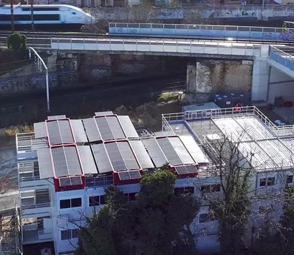 Vue aérienne d’un toit modulaire équipé du système SOLAR 4.0 d’Altempo avec panneaux photovoltaïques près d’une voie ferrée