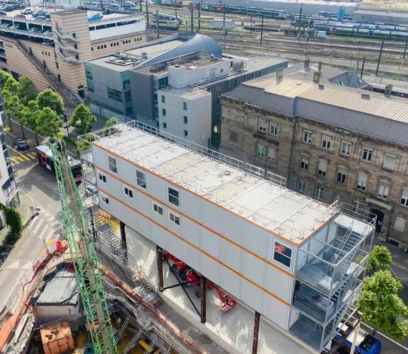Vue aérienne d’un bâtiment modulaire ALGECO® installé en milieu urbain au-dessus d’un chantier ferroviaire