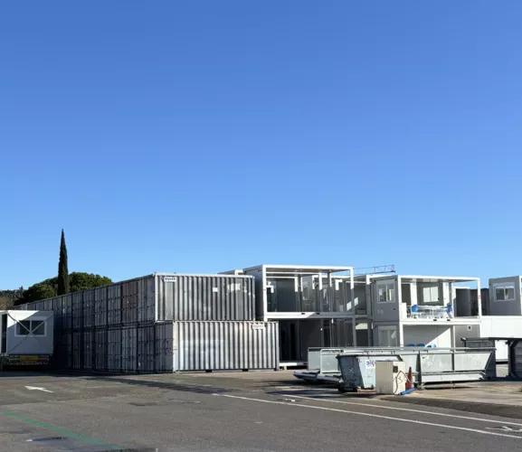 Empilement de modules modulaires ALGECO® sur parc logistique en extérieur sous ciel dégagé