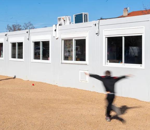 Bâtiment scolaire modulaire ALGECO® blanc avec enfants dans la cour de l’école de Marsat