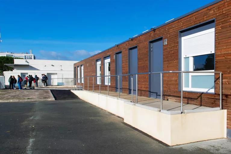 Salle de classe modulaire avec bardage en bois Algeco et rampe d’accès