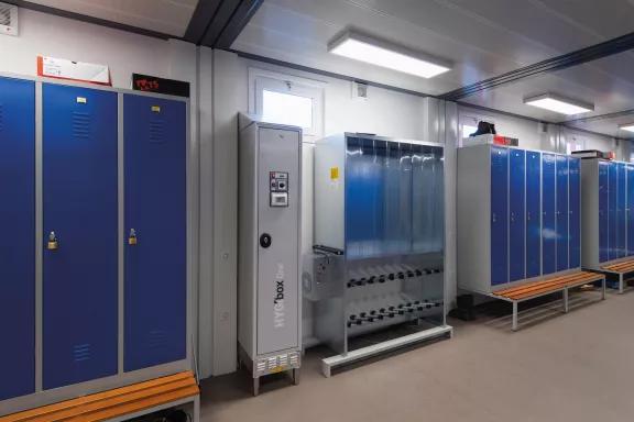 Vestiaire modulaire industriel ALGECO® avec casiers bleus et système de séchage d'équipements
