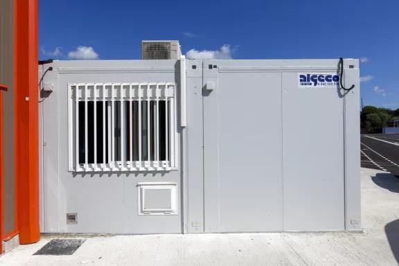 Façade extérieure d’un bureau modulaire d’occasion ALGECO® avec fenêtre sécurisée et climatisation.