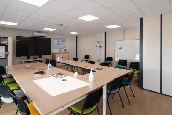 Salle de réunion modulaire ALGECO® équipée d’un écran et de mobilier contemporain