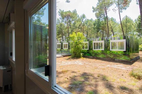vue depuis une fenêtre du complexe de logements modulaires ALGECO® temporaire avec façade en trompe l’œil dans une forêt d’Arès (Bassin d’Arcachon)
