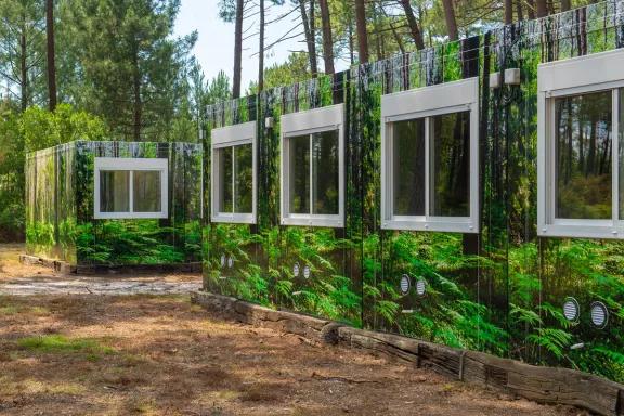 Vue rapprochée d’une des façades du complexe de logements modulaires ALGECO® temporaire avec façade en trompe l’œil dans une forêt d’Arès (Bassin d’Arcachon)