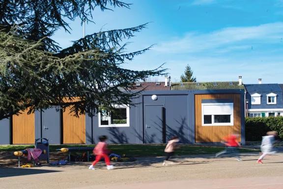 Bâtiment modulaire scolaire ALGECO® avec enfants jouant en extérieur