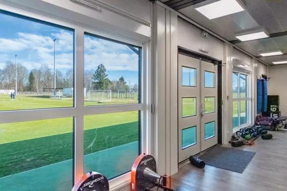 Centre d’entraînement sportif modulaire ALGECO® avec vue sur terrain de football à Pau