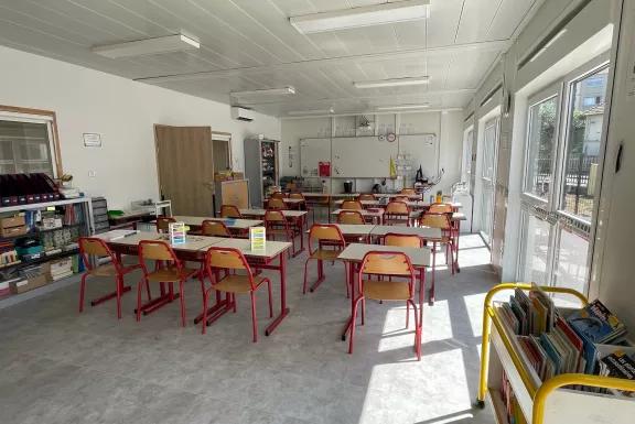 Salle de classe modulaire ALGECO® ensoleillée avec mobilier scolaire coloré et bibliothèque mobile