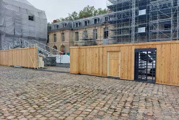 Accès sécurisé sur chantier patrimonial avec clôture en bois et tourniquet installé par Altempo