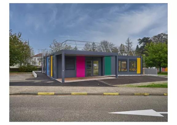 Bâtiment scolaire modulaire Algeco coloré installé à Cernay, avec toiture technique et façades multicolores