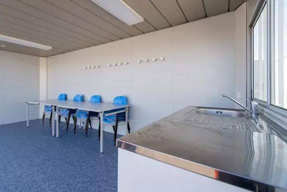  Intérieur d’un module modulaire ALGECO® reconditionné aménagé en salle de pause avec évier et table